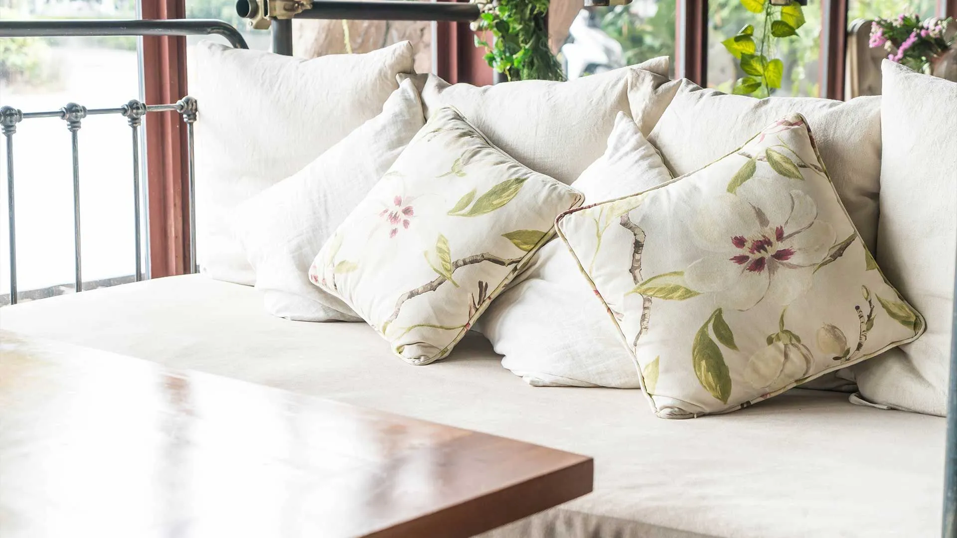 Custom floral throw pillows on a cream linen daybed